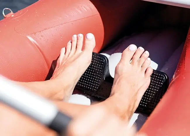 Laad afbeelding in galerijtoner, Een close-up van blote voeten op zwarte voetsteunen in een rode Intex Excursion Pro K1 Opblaasbare Kayak