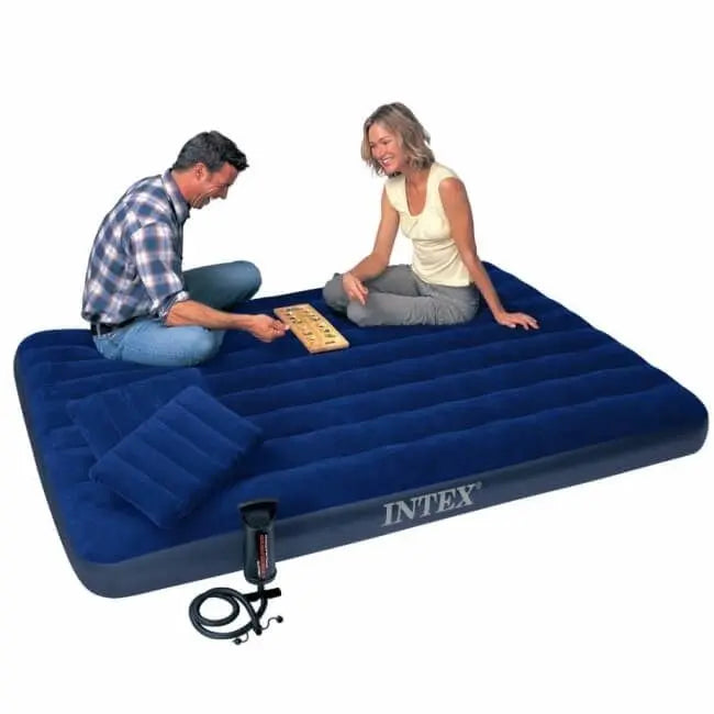 Laad afbeelding in galerijtoner, Een man en vrouw spelen een bordspel op een Intex Classic Dura-Beam Complete Set. Ze genieten van een heerlijk slaapcomfort met een kussen en luchtpomp binnen handbereik.