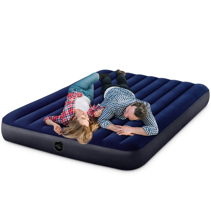 Laad afbeelding in galerijtoner, Twee mensen ontspannen op een Intex Classic Dura-Beam Tweepersoons Luchtbed, een donkerblauw opblaasbaar luchtbed, tegen een witte achtergrond.