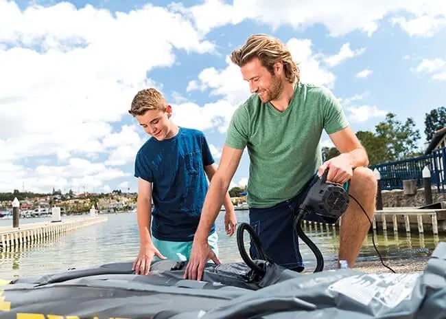 Laad afbeelding in galerijtoner, Elektrische pomp in gebruik door twee personen om een boot op te blazen.