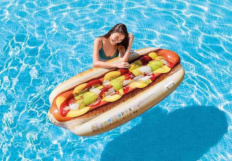 Laad afbeelding in galerijtoner, Vrouw die in het water staat en die leunt op een hot dog luchtbed.
