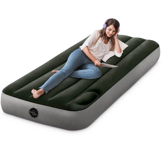 Een vrouw met een koptelefoon ontspant en glimlacht terwijl ze een tablet gebruikt op een Intex Prestige Downy Eenpersoons Luchtbed (Klein) van Intex.