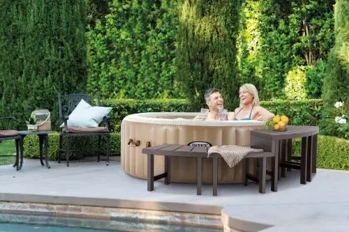 Twee spabankjes naast een opblaasbare jacuzzi waar twee mensen in zitten.