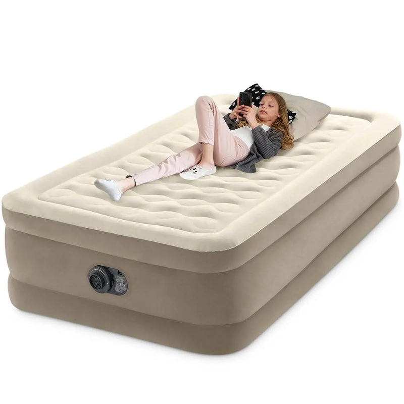Laad afbeelding in galerijtoner, Een vrouw ontspant op een Intex Ultra Pluche Eenpersoons Luchtbed, gebruikt haar telefoon en laat haar hoofd op een kussen rusten.