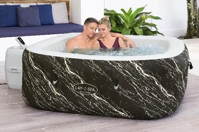 Laad afbeelding in galerijtoner, Twee personen zitten in zwarte opblaasbare spa met water en bubbels