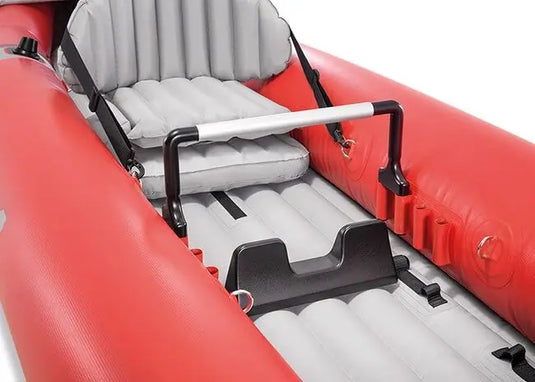 Close-up van een rood met grijze Intex Excursion Pro K1 opblaasbare kajakzitting met zwarte handgrepen en een steunstang
