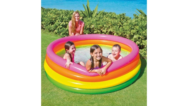 Laad afbeelding in galerijtoner, Drie kinderen zwemmen in een rond opblaasbaar kinderzwembad Intex Sunset Glow met een groene, gele, oranje en roze band terwijl het bad in de achtertuin staat
