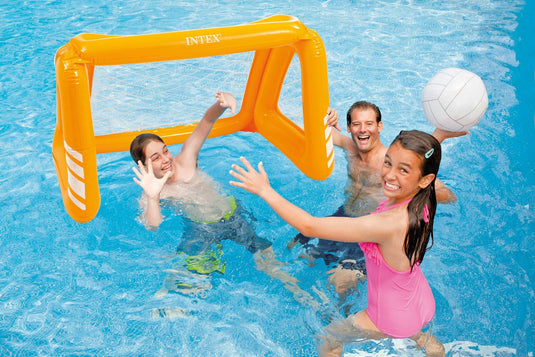 Drie personen spelen in het water met een witte opblaasbare bal en een oranje opblaasbaar voetbalgoal