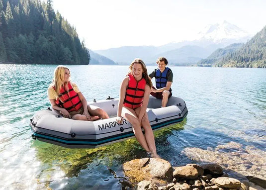 Drie personen zitten op een drijvende grijze Intex Mariner 3 opblaasboot