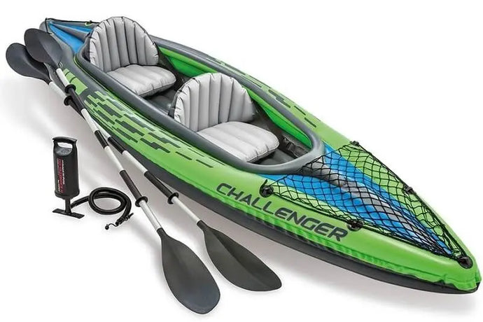 Een groene Intex Challenger K2 opblaasbare kayak met twee zwarte peddels en een zwarte handpomp
