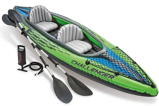 Een groene Intex Challenger K2 opblaasbare kayak met twee zwarte peddels en een zwarte handpomp