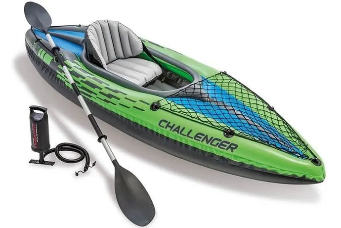 Een groene opblaasbare Intex Challenger K1 kayak met een zwarte peddel en een zwarte handpomp