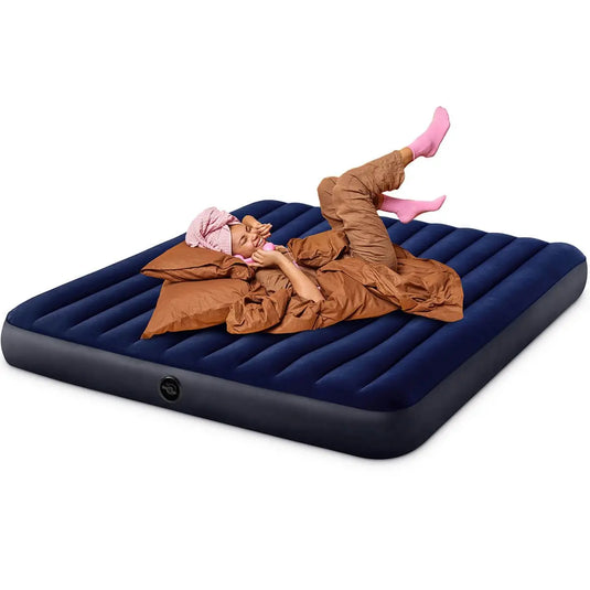 Een vrouw ligt op een donkerblauw Intex Classic Dura Beam kingsize opblaasbaar luchtbed