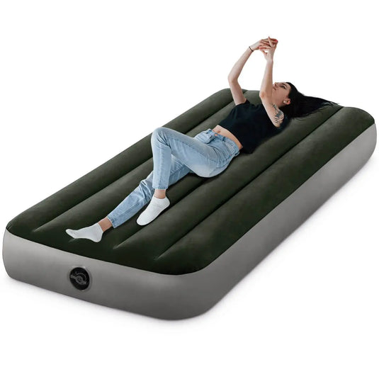 Een vrouw ligt op een zwart Intex Prestige Downy Eenpersoons Luchtbed met een ingebouwd ventiel