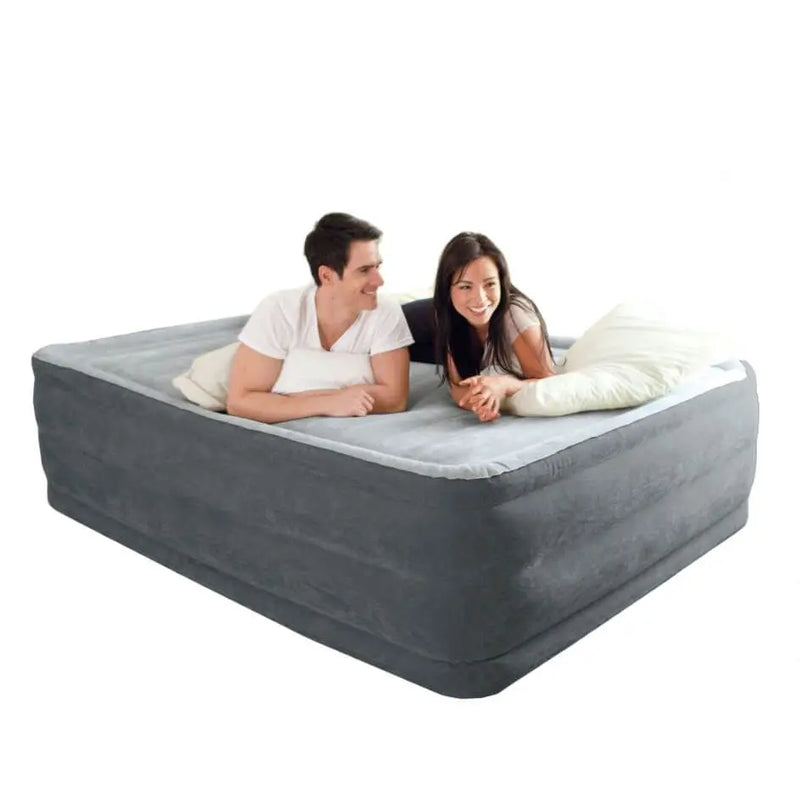 Laad afbeelding in galerijtoner, Twee personen ontspannen op het Intex Comfort Plush Tweepersoons Luchtbed, glimlachen naar elkaar en genieten van de ondersteuning van Intex&#39;s Fiber-Tech® technologie.

