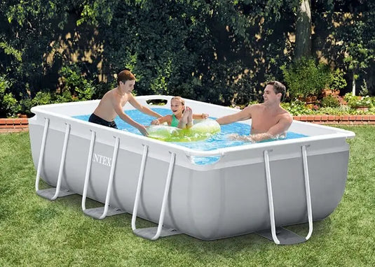 Drie personen genieten van een zonnige dag in de achtertuin en spelen in een Intex Prism Frame Zwembad 300 x 175 x 80cm met filterpomp.