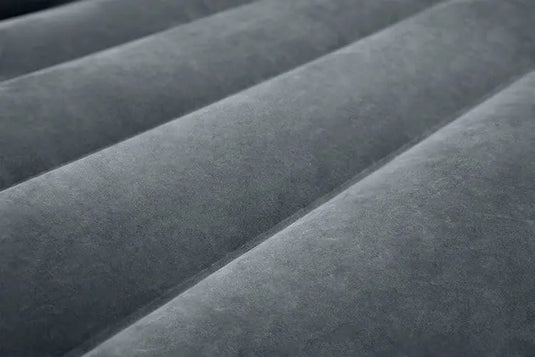 Close-up van een grijs, getextureerd tweepersoonsluchtbed met horizontale ribbels, in de stijl van de Intex Pull-Out Opblaasbare Bank van Intex.