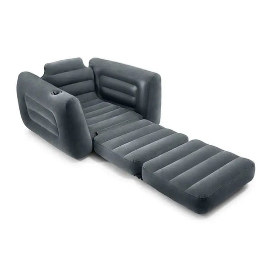 De Intex Pull-Out Opblaasbare Stoel van Intex is voorzien van een verlengde voetensteun en armleuningen, waardoor deze eenvoudig om te bouwen is tot eenpersoonsluchtbed voor extra comfort en veelzijdigheid; hier afgebeeld in het grijs op een witte achtergrond.