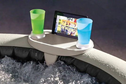 Lichtgevend LED dienblad met een tablet en twee drankjes aan een jacuzzirand.
