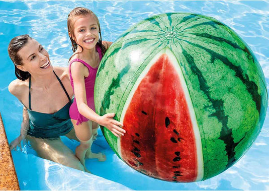 Twee personen in het water die spelen met een strandbal in de vorm van een watermeloen.