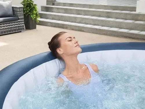 Vrouw geniet van de bubbels in de opblaasbare jacuzzi.