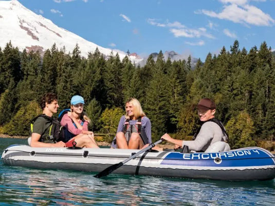 Vier personen varen op het water in een grijze Intex Excursion 4 opblaasbare boot