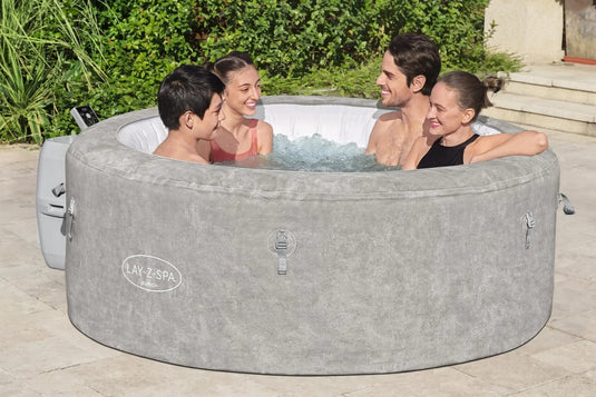 Vier personen zitten in een opblaasbare spa met bubbels