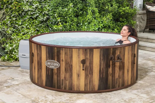 Vrouw ligt in bruine opblaasbare spa met houtlook
